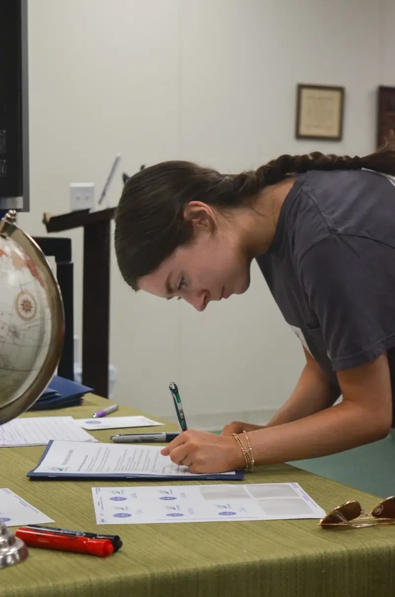 A student writing on a worksheet during the session