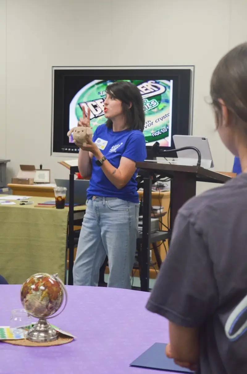 A facilitator presenting to students from the podium