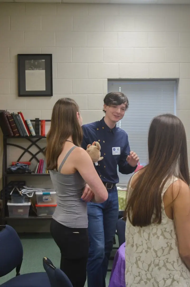 A student leading a small group conversation with two others