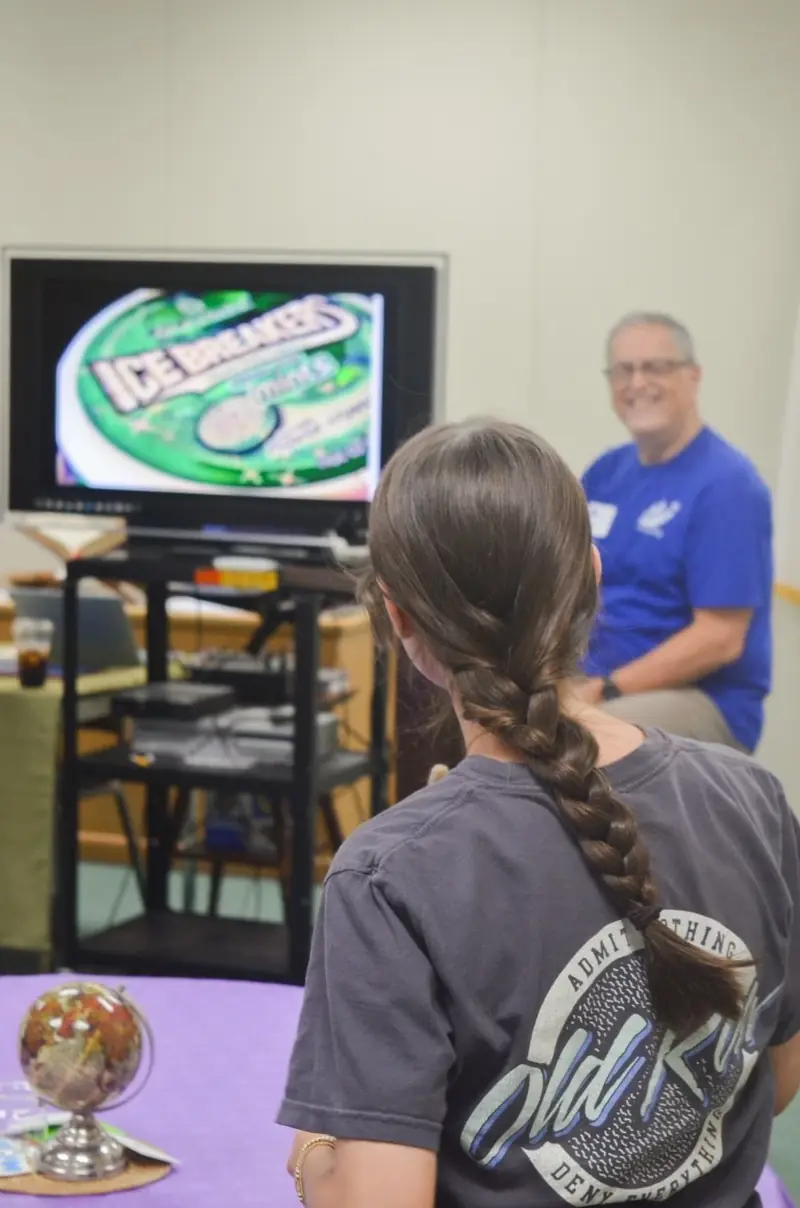 A student watching the presentation while a facilitator looks on