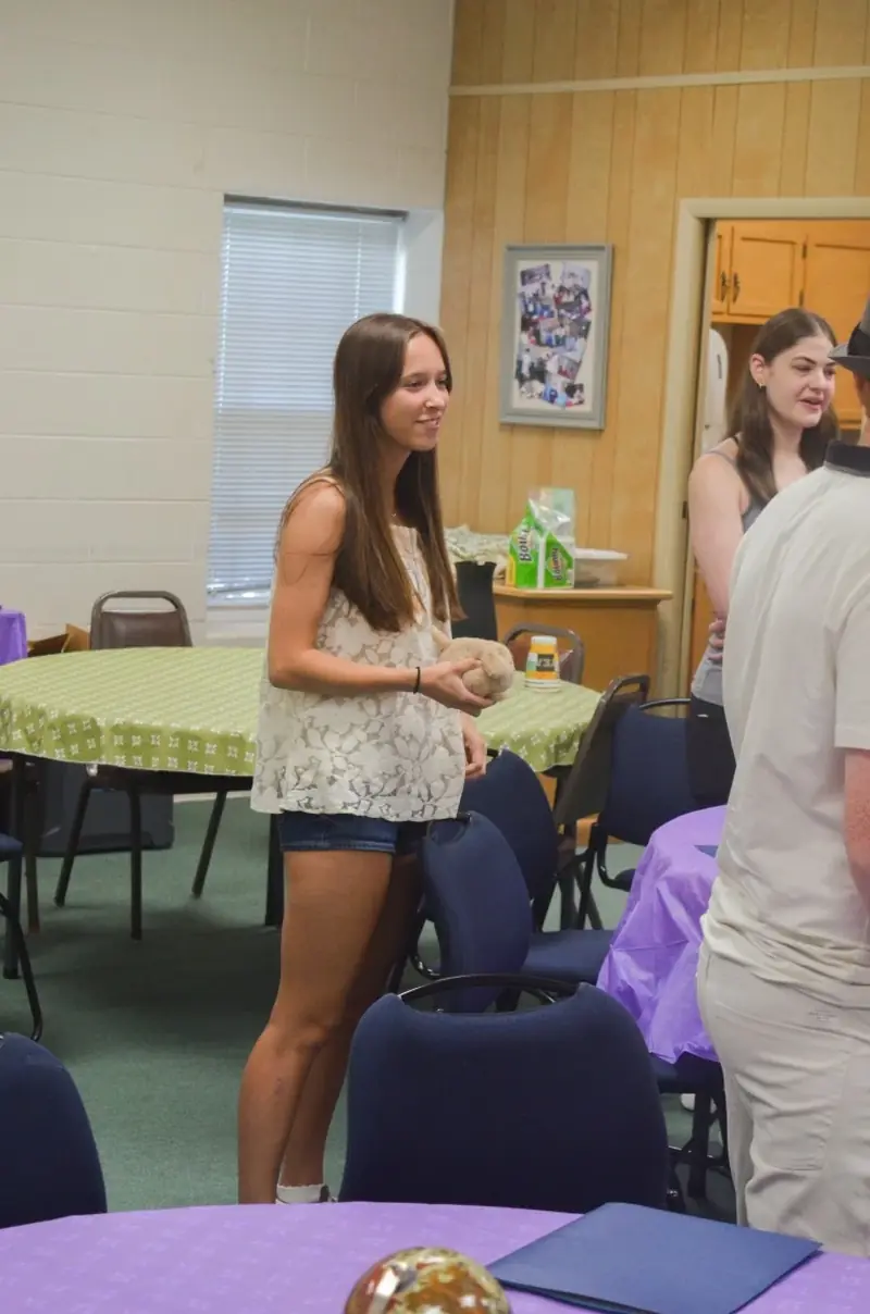 A student moving between tables during a group activity