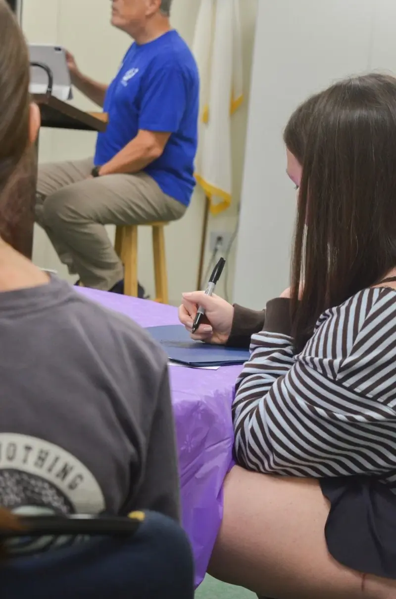 A student taking notes while Don Walter teaches