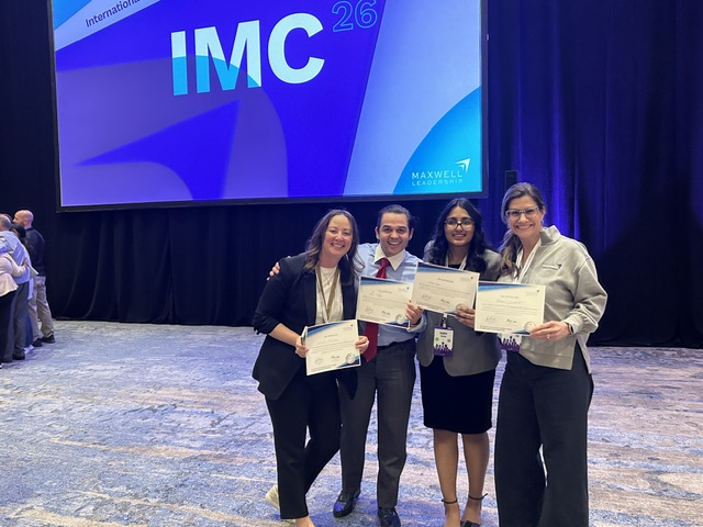 Graduates holding certificates at a Maxwell Leadership event